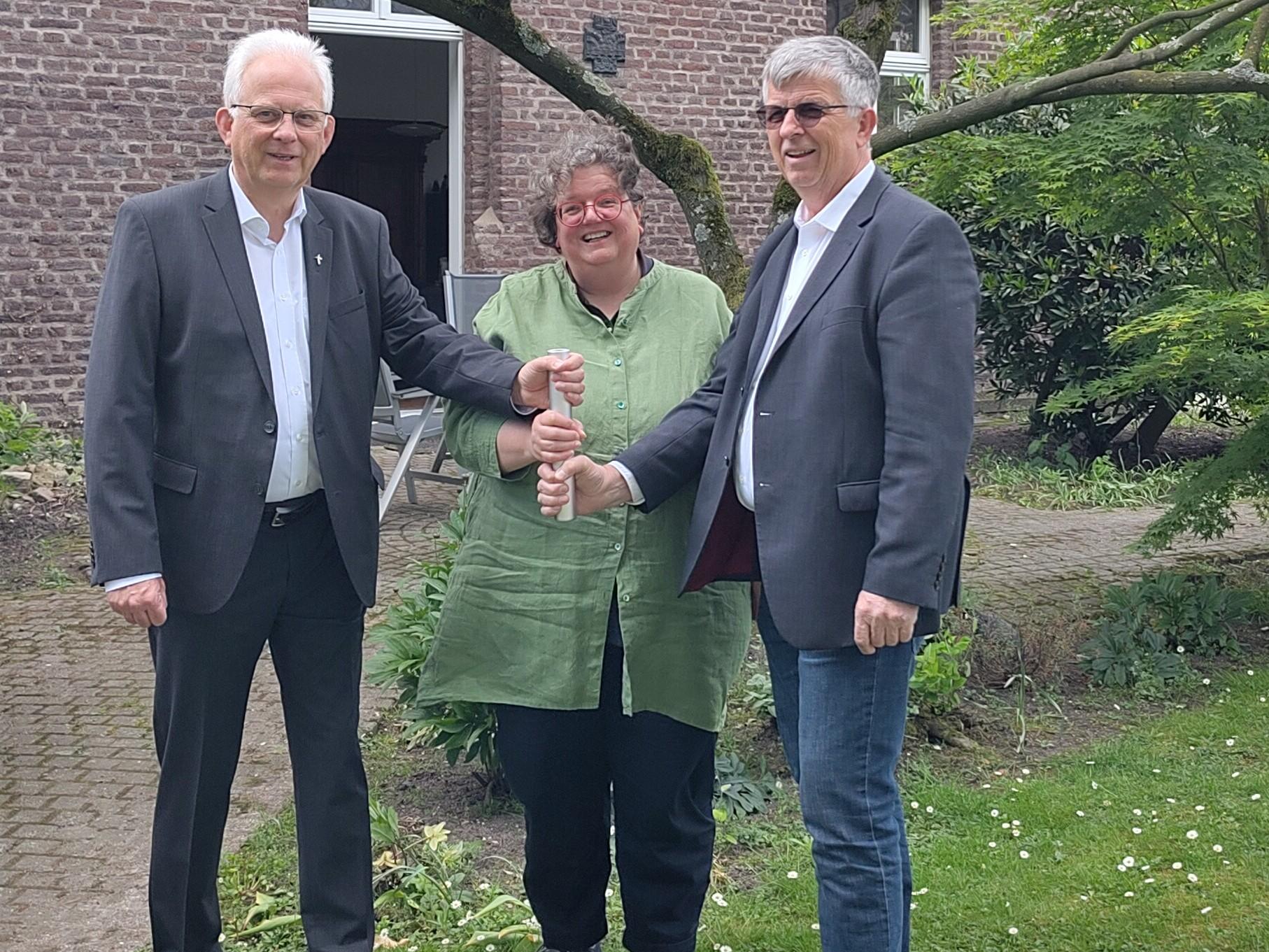 Als Team in der Region unterwegs: Propst Thomas Eicker (l.), Gabi Terhorst und Harald Hüller. Symbolisch teilen sie sich einen Staffelstab.